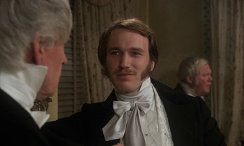 Movie still from “The Europeans” (1979), directed by James Ivory – A man in a suit with a white bow tie; Close Up shot, Over the shoulder angle