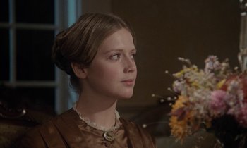 Movie still from “The Europeans” (1979), directed by James Ivory – A young woman in a brown dress looking to her left; Close Up shot, Over the shoulder angle