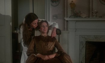 Movie still from “The Europeans” (1979), directed by James Ivory – A woman sitting next to another woman in front of a fire place; Medium shot, Over the shoulder angle