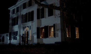 Movie still from “The Europeans” (1979), directed by James Ivory – Two people standing in front of a white building; Extreme Wide shot, Over the shoulder angle