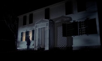 Movie still from “The Europeans” (1979), directed by James Ivory – A person standing in front of a building at night; Extreme Wide shot, Low angle