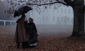 Movie still from “The Europeans” (1979), directed by James Ivory – A man and a woman walking under an umbrella; Wide shot, Over the shoulder angle