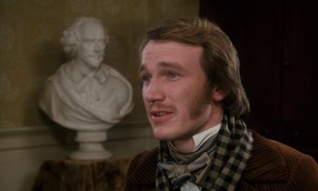 Movie still from “The Europeans” (1979), directed by James Ivory – A man in a plaid shirt and a checkered scarf; Close Up shot, Over the shoulder angle