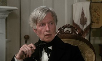 Movie still from “The Europeans” (1979), directed by James Ivory – An older man wearing a suit and bow tie; Close Up shot, Over the shoulder angle
