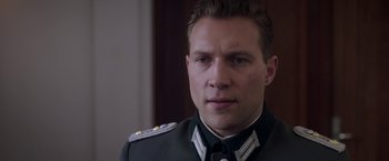 Movie still from “The Exception” (2016), directed by David Leveaux – A person wearing a military uniform; Close Up shot, Over the shoulder angle