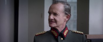Movie still from “The Exception” (2016), directed by David Leveaux – An older man in a military uniform looking to his left; Close Up shot, Over the shoulder angle