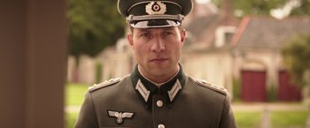 Movie still from “The Exception” (2016), directed by David Leveaux – A person wearing a military uniform; Close Up shot, Low angle