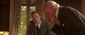 Movie still from “The Exception” (2016), directed by David Leveaux – Two men in suits and ties are looking at each other in the mirror; Close Up shot, Over the shoulder angle
