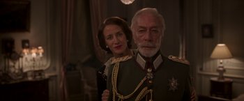 Movie still from “The Exception” (2016), directed by David Leveaux – An older man and a younger woman dressed in military uniforms; Medium shot, Low angle