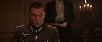 Movie still from “The Exception” (2016), directed by David Leveaux – A man in a military uniform is looking at the camera; Close Up shot, Low angle
