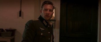 Movie still from “The Exception” (2016), directed by David Leveaux – A man in a military uniform standing next to a door; Close Up shot, Over the shoulder angle