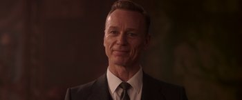 Movie still from “The Exception” (2016), directed by David Leveaux – A person wearing a suit and tie; Close Up shot, Low angle