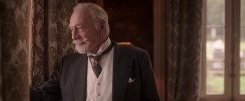 Movie still from “The Exception” (2016), directed by David Leveaux – An older man wearing a suit and tie; Close Up shot, Over the shoulder angle
