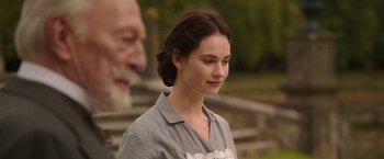Movie still from “The Exception” (2016), directed by David Leveaux – A young woman is standing in front of an older man; Close Up shot, Over the shoulder angle