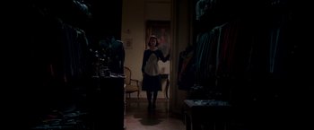 Movie still from “The Exception” (2016), directed by David Leveaux – A woman is standing in a dark room; Wide shot, High angle