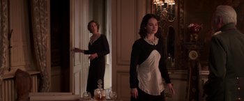 Movie still from “The Exception” (2016), directed by David Leveaux – Two women standing in front of a mirror in a room; Medium shot, Low angle