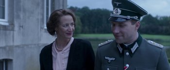 Movie still from “The Exception” (2016), directed by David Leveaux – A man and a woman are standing next to each other; Close Up shot, Over the shoulder angle