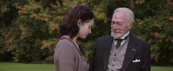 Movie still from “The Exception” (2016), directed by David Leveaux – An older man standing next to a young woman; Medium shot, Over the shoulder angle