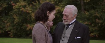 Movie still from “The Exception” (2016), directed by David Leveaux – An older man and a younger woman standing next to each other; Medium shot, Over the shoulder angle