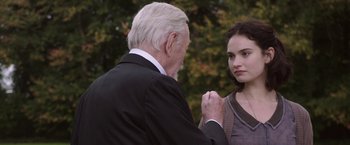 Movie still from “The Exception” (2016), directed by David Leveaux – An older man and a young woman standing next to each other; Close Up shot, Over the shoulder angle