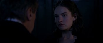 Movie still from “The Exception” (2016), directed by David Leveaux – A young woman looking at the camera while standing next to a young man; Close Up shot, Over the shoulder angle