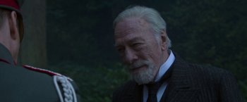 Movie still from “The Exception” (2016), directed by David Leveaux – An old man with a beard and a black tie; Close Up shot, Over the shoulder angle