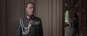 Movie still from “The Exception” (2016), directed by David Leveaux – A person wearing a military uniform; Medium shot, Low angle