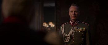 Movie still from “The Exception” (2016), directed by David Leveaux – A person wearing a military uniform; Close Up shot, Over the shoulder angle