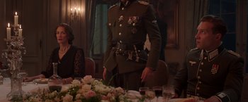 Movie still from “The Exception” (2016), directed by David Leveaux – A man in a military uniform standing in front of a table; Medium shot, Over the shoulder angle