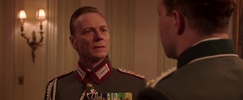 Movie still from “The Exception” (2016), directed by David Leveaux – A man in a military uniform talking to another man; Close Up shot, Over the shoulder angle