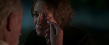 Movie still from “The Exception” (2016), directed by David Leveaux – An older woman holding a cell phone up to her ear; Close Up shot, Over the shoulder angle