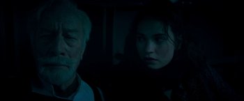 Movie still from “The Exception” (2016), directed by David Leveaux – A man and a woman standing next to each other in the dark; Close Up shot, Over the shoulder angle