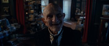 Movie still from “The Extraordinary Adventures of Adèle Blanc-Sec” (2010), directed by Luc Besson – An old man wearing a suit and a tie; Close Up shot, Low angle