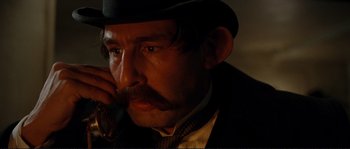 Movie still from “The Extraordinary Adventures of Adèle Blanc-Sec” (2010), directed by Luc Besson – A person wearing a suit and hat; Close Up shot, Low angle