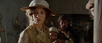 Movie still from “The Extraordinary Adventures of Adèle Blanc-Sec” (2010), directed by Luc Besson – A group of people standing next to each other in a room; Medium shot, Over the shoulder angle