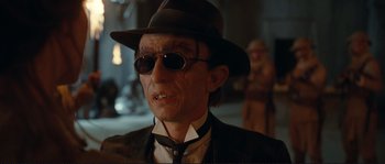 Movie still from “The Extraordinary Adventures of Adèle Blanc-Sec” (2010), directed by Luc Besson – An older man wearing a hat and sunglasses; Close Up shot, Over the shoulder angle