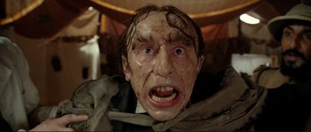 Movie still from “The Extraordinary Adventures of Adèle Blanc-Sec” (2010), directed by Luc Besson – A man's face with a creepy expression; Close Up shot, Low angle