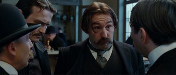 Movie still from “The Extraordinary Adventures of Adèle Blanc-Sec” (2010), directed by Luc Besson – A person wearing a suit and tie; Close Up shot, Low angle