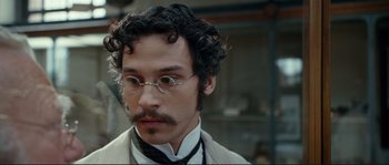 Movie still from “The Extraordinary Adventures of Adèle Blanc-Sec” (2010), directed by Luc Besson – A person wearing glasses and a suit; Close Up shot, High angle