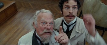 Movie still from “The Extraordinary Adventures of Adèle Blanc-Sec” (2010), directed by Luc Besson – A man with a beard and mustache and a man with a beard and a mustache; Close Up shot, Low angle