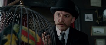 Movie still from “The Extraordinary Adventures of Adèle Blanc-Sec” (2010), directed by Luc Besson – A man in a top hat holding onto a bird cage; Close Up shot, Low angle