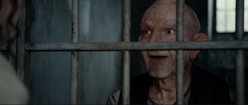 Movie still from “The Extraordinary Adventures of Adèle Blanc-Sec” (2010), directed by Luc Besson – An old man looking through the bars of a jail cell; Close Up shot, Over the shoulder angle