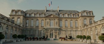 Movie still from “The Extraordinary Adventures of Adèle Blanc-Sec” (2010), directed by Luc Besson – A horse drawn carriage in front of a large building; Extreme Wide shot, Low angle