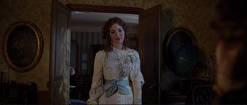 Movie still from “The Extraordinary Adventures of Adèle Blanc-Sec” (2010), directed by Luc Besson – A woman in a white dress standing in front of a mirror; Medium shot, Over the shoulder angle