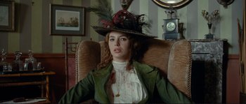 Movie still from “The Extraordinary Adventures of Adèle Blanc-Sec” (2010), directed by Luc Besson – A woman wearing a hat sitting in a chair; Medium shot, Low angle