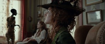 Movie still from “The Extraordinary Adventures of Adèle Blanc-Sec” (2010), directed by Luc Besson – A woman in a hat is looking to the side; Close Up shot, Over the shoulder angle