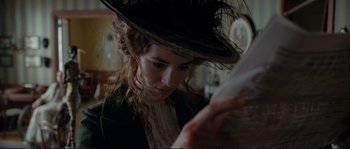 Movie still from “The Extraordinary Adventures of Adèle Blanc-Sec” (2010), directed by Luc Besson – A woman wearing a hat looking down at a paper; Close Up shot, Low angle