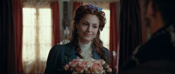 Movie still from “The Extraordinary Adventures of Adèle Blanc-Sec” (2010), directed by Luc Besson – A beautiful young woman holding a bouquet of flowers; Close Up shot, Over the shoulder angle