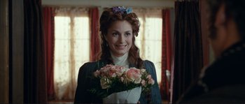 Movie still from “The Extraordinary Adventures of Adèle Blanc-Sec” (2010), directed by Luc Besson – A woman holding a bouquet of flowers in her hands; Close Up shot, Over the shoulder angle