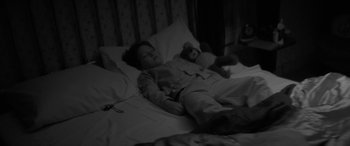 Movie still from “The Eyes of My Mother” (2016), directed by Nicolas Pesce – A child sleeping in a bed with a teddy bear; Medium shot, High angle